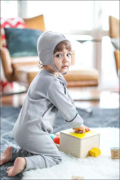 Smart Footed One-Piece + Bib in gray on child with hat, 100% organic cotton.