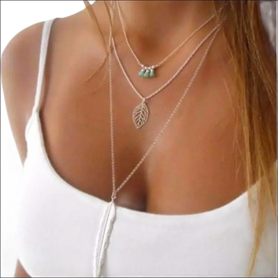 Turquoise Leaf Feather multi-layer necklace with natural turquoise stones on silver chains worn over white top